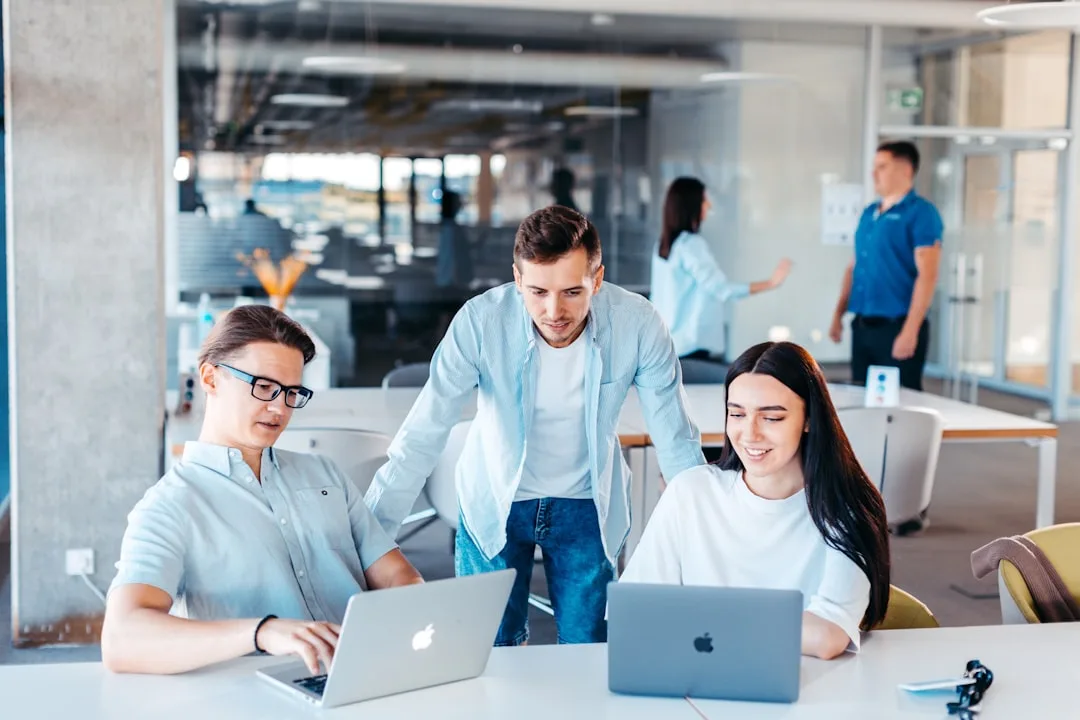 Team collaborating around a laptop in an office