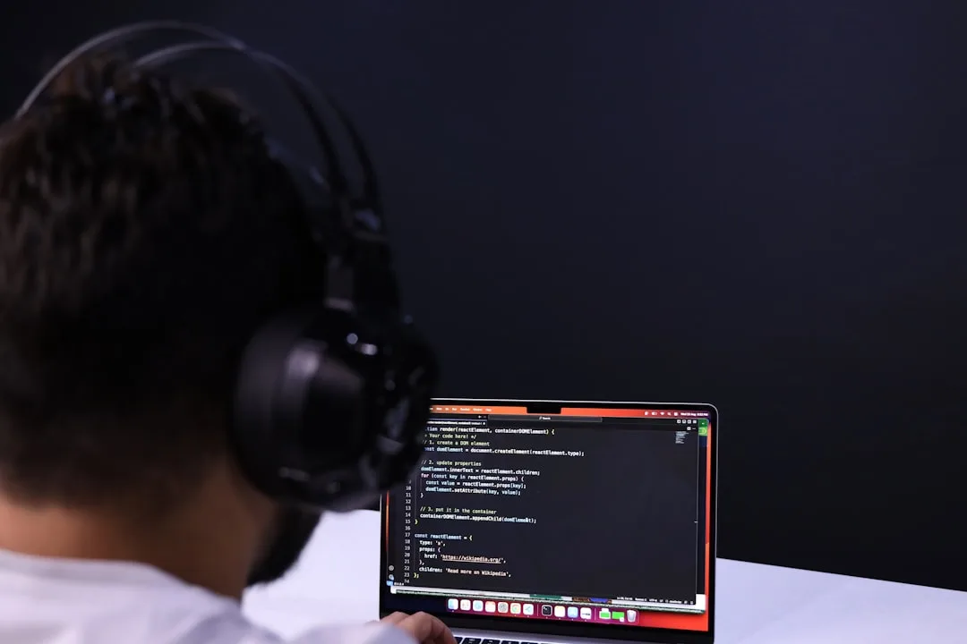 Developer focused on laptop with headphones